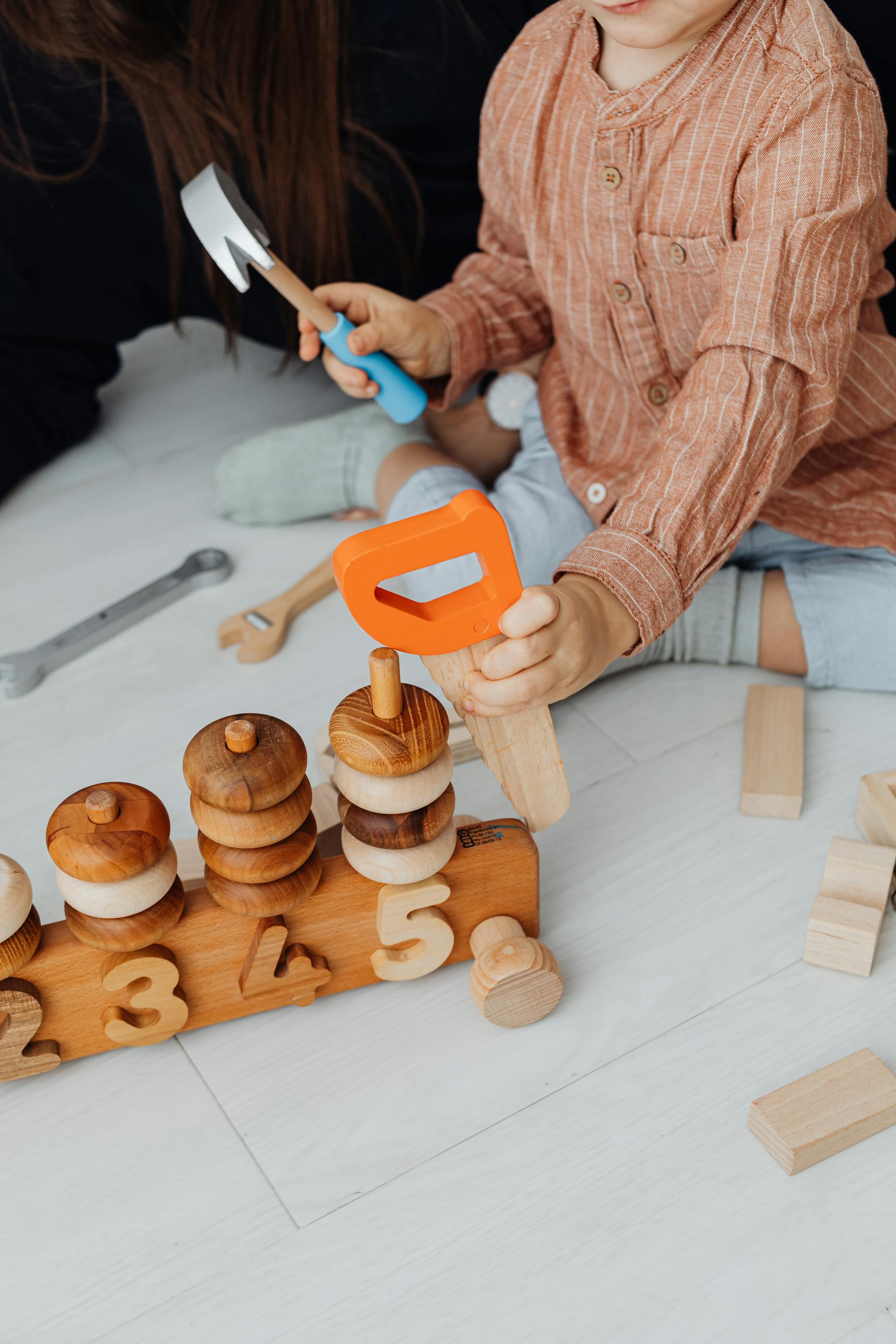 Enfant decouvrant des jouets educatifs en bois dans un interieur chaleureux